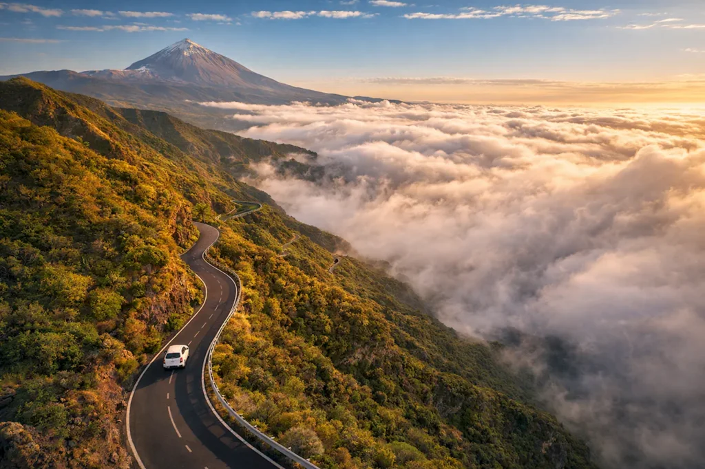 Серпантин TF-24 — одна из живописных дорог острова, доступных только на машине Арендованный автомобиль на горном серпантине Тенерифе с видом на вулкан Тейде