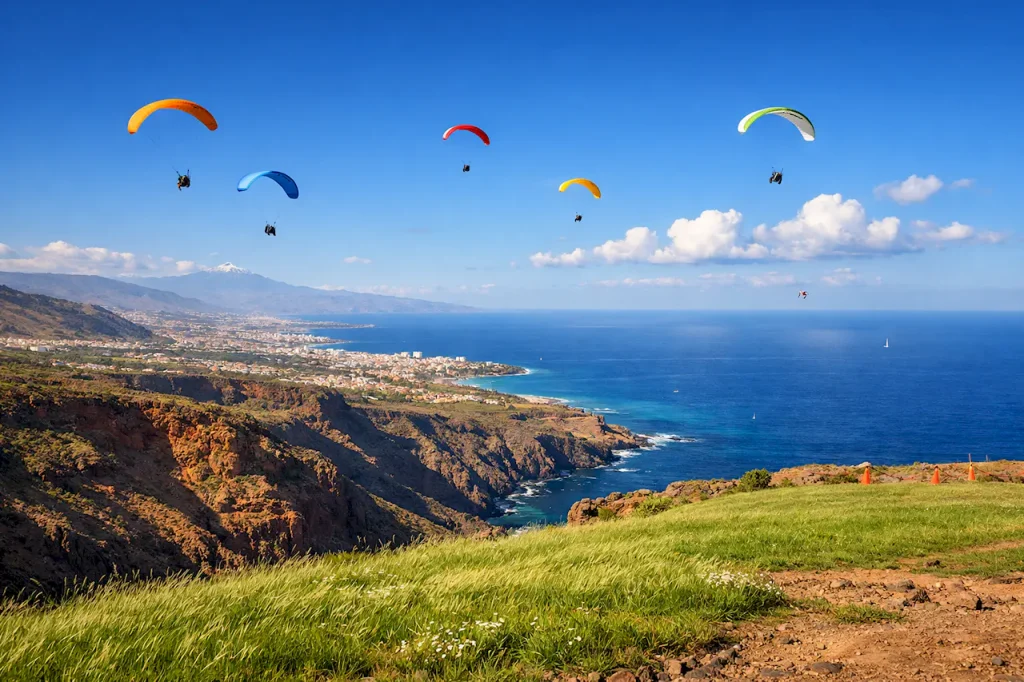 Идеальные условия для параглайдинга на южном побережье Тенерифе: ясное небо, легкий ветер, парапланы в полете